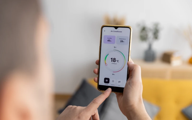 Mann steuert Smarthome mit Handy-App