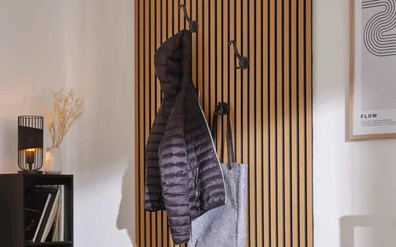 Flur mit hellbraunen Holzpaneelen an der Wand und daraufliegender Garderobe 