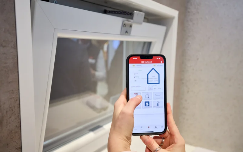 Frau steuert Fenster im Smart-Home mit einer App