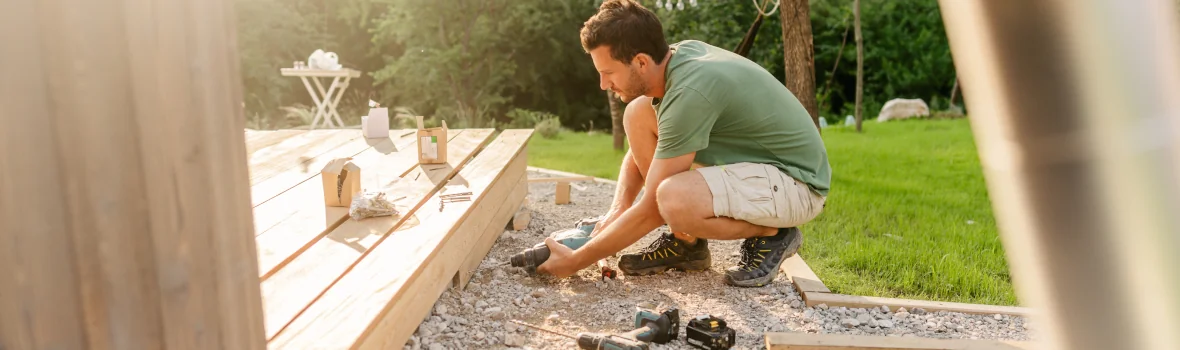 Schreiner beim Einbau von Terrassendielen im Garten