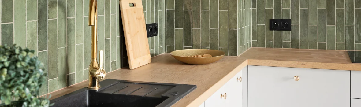 Küchenzeile mit Küchenrückwand aus grünem Mosaik aus den Fliesentrends 2025 