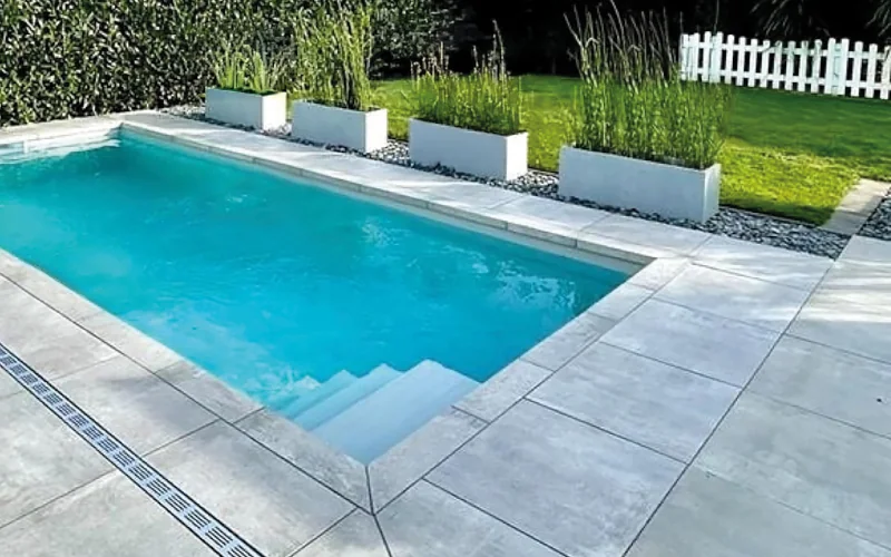 Pool umrandet mit Terrassenplatten und Grünpflanzen