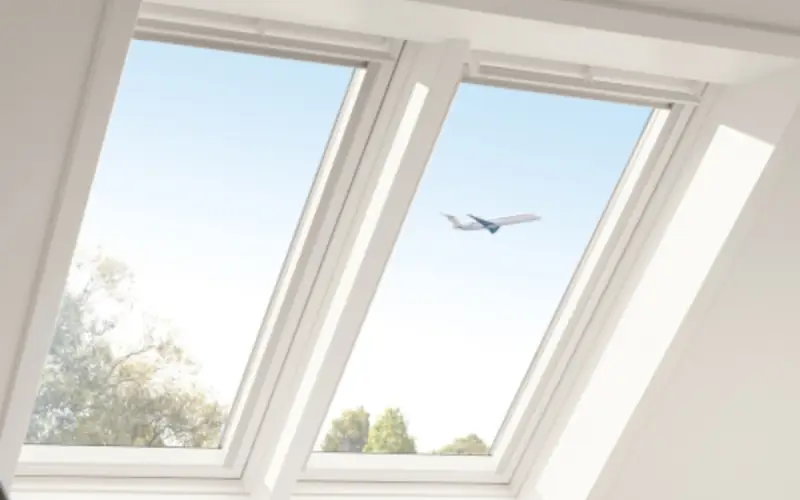 Flugzeug am Himmel durch Dachfenster sichtbar, klare Sicht.