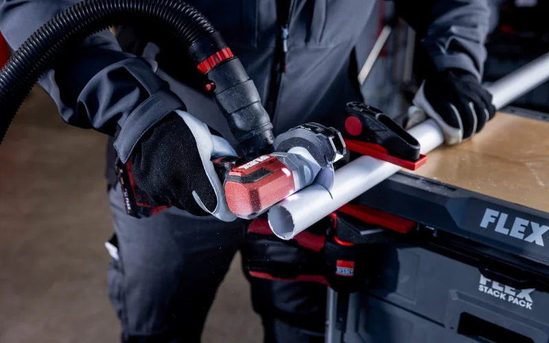 Flex Mini-Winkelschleifer schneidet einen Metallrohr