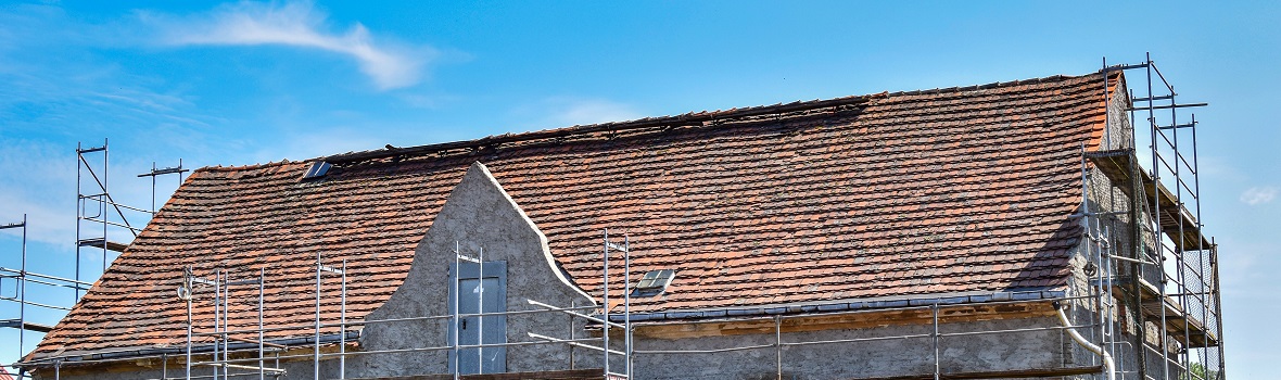 Hausdach in der Sanierung mit viel Gerüst um das Haus herum 