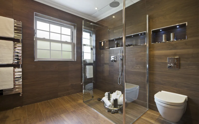 Modernes Badezimmer mit Dusche, Toilette und Handtuchhalter.