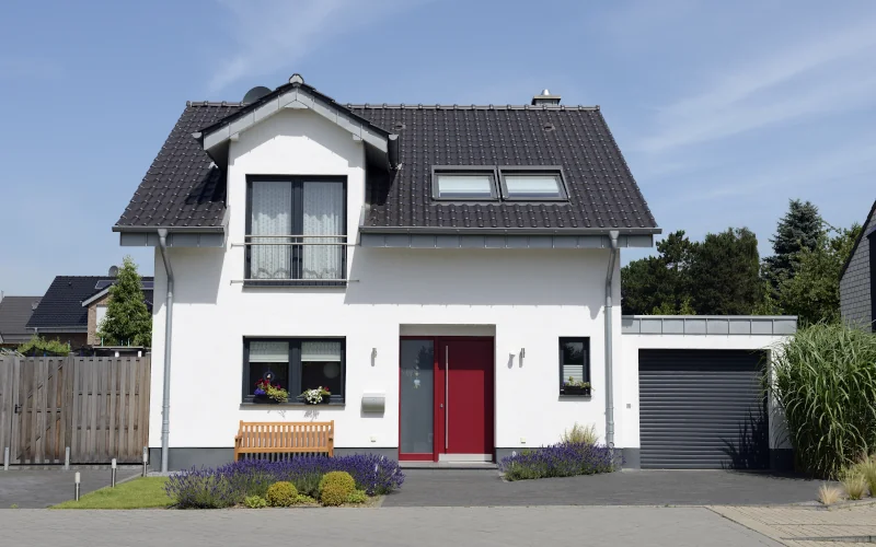 Einfamilienhaus mit weißer Fassade und grauem Dach