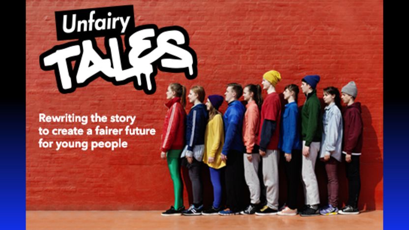 A group of young people stood in a line against a wall with graffiti that says 'Unfairy tales'