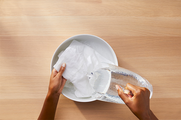 A person rinsing white garment