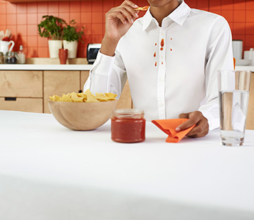 A person wearing a white shirt stained with salsa sauce