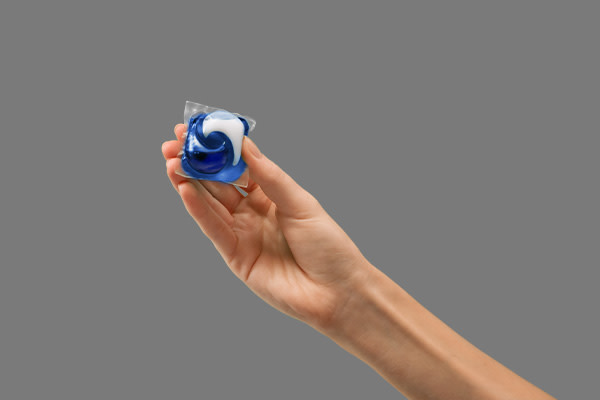 A person holding a Tide PODS washing capsule