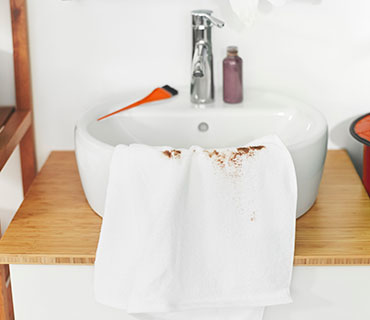 White towel stained with hairdye in the sink