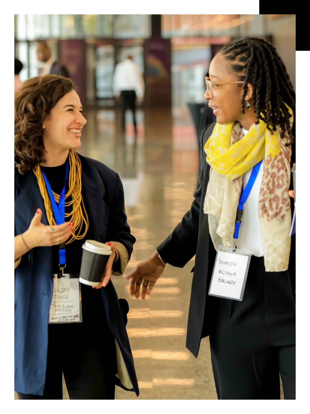 two women with lanyards, talking