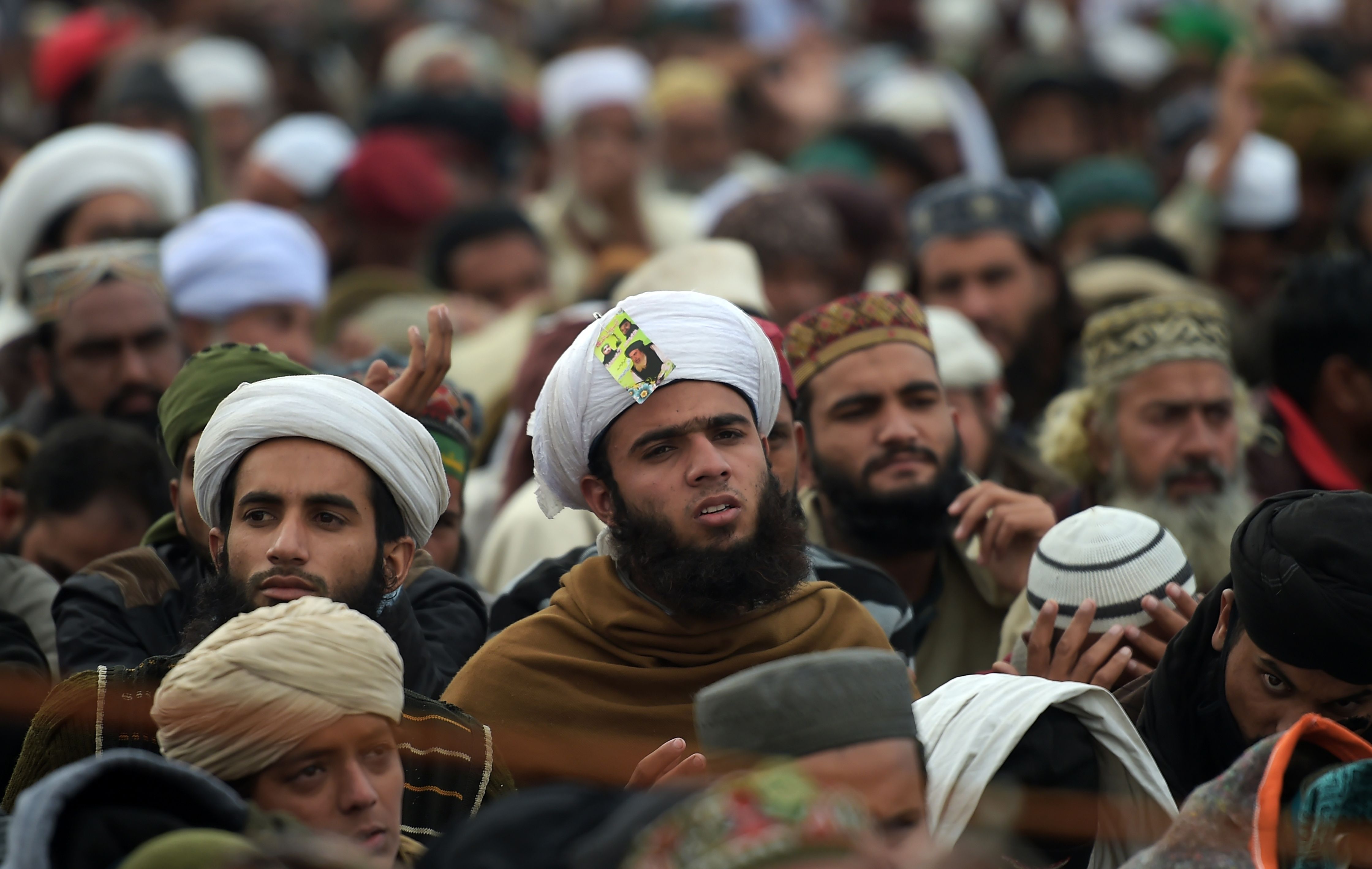 pakistans-emboldened-islamists - Pakistani supporters of the Tehreek-i-Labaik Yah Rasool Allah Pakistan (TLYRAP) religious group listen to their leader Khadim Hussain Rizvi while as he announces the end of sit-in protest on a blocked flyover bridge during a press conference in Islamabad on 27 November, 2017