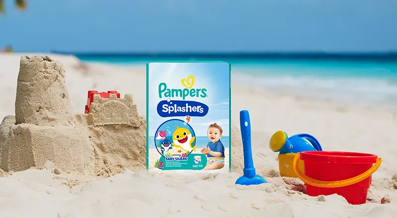Pachet Pampers Splashers cu plajă, castel de nisip și jucării de plajă.