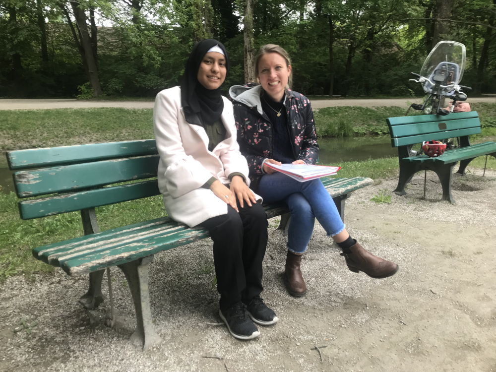 Fereshta Ibrahimi und Lisa Riedel auf einer Bank im Park