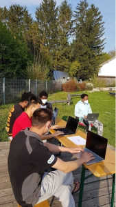 Laptops mit Nutzern in München draußen bei Sonnenschein