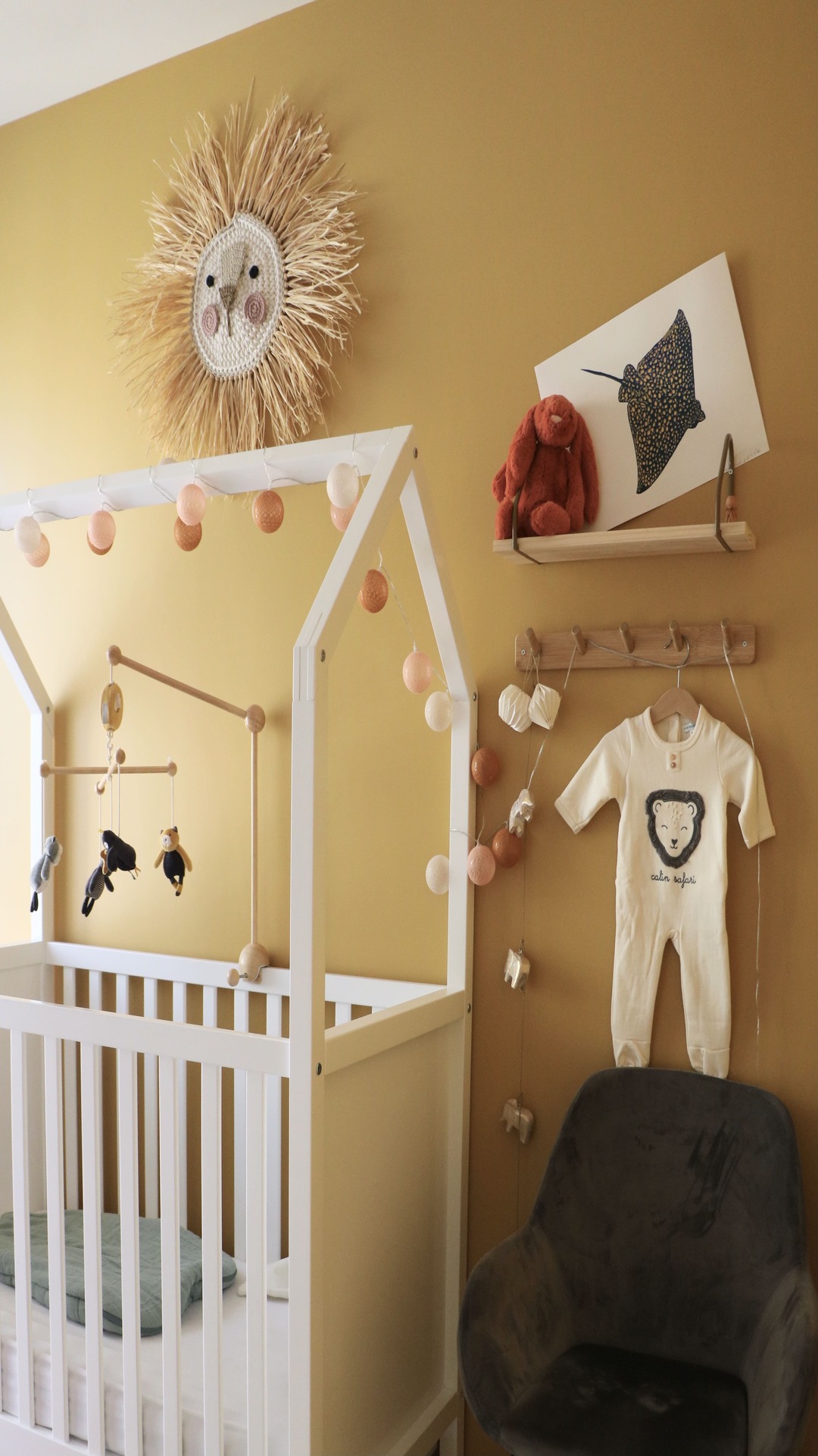 chambre enfant avec lit blanc et porte manteau en bois blanc et chaise noir