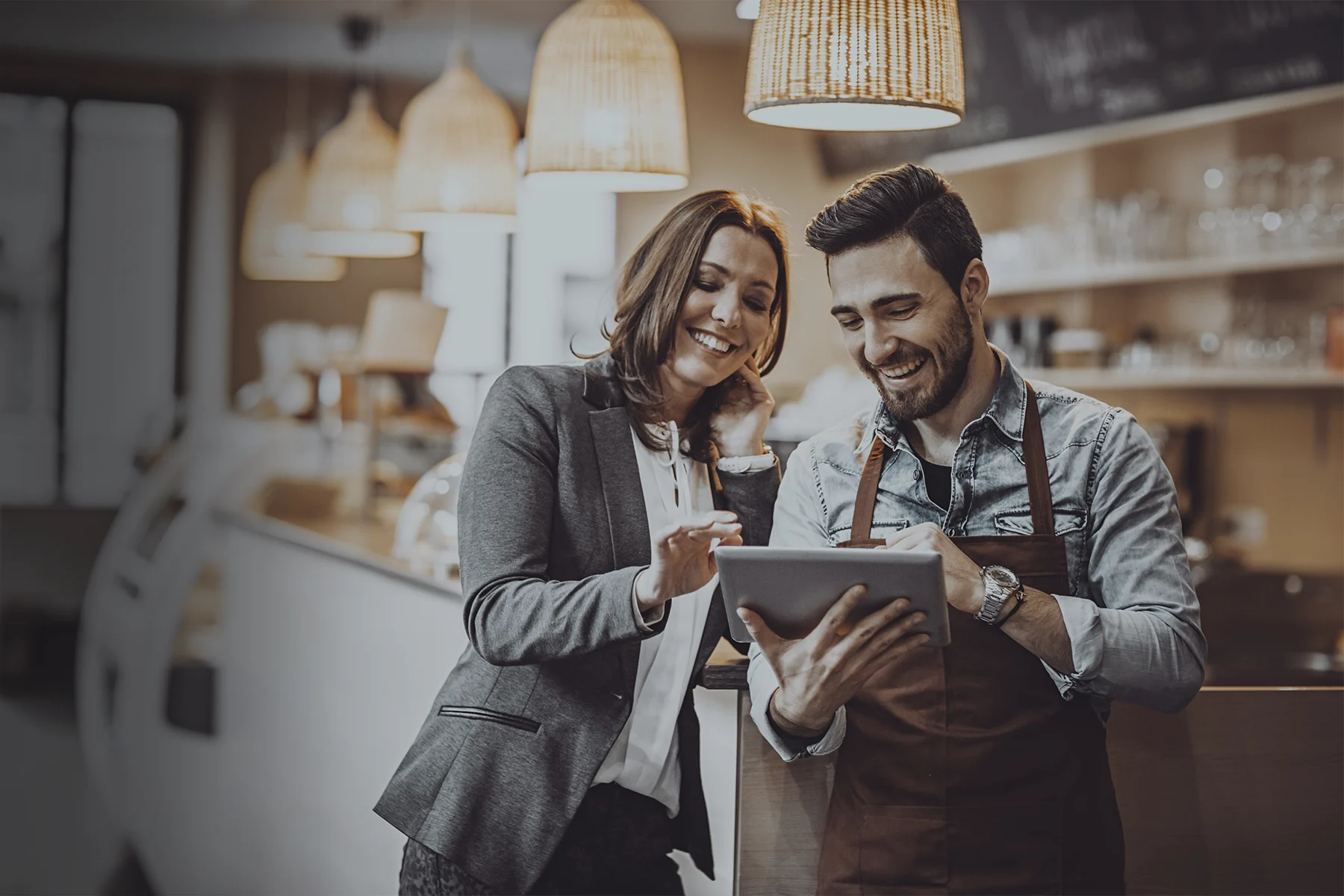 Mannelijke barista en vrouw scrollen op een tablet