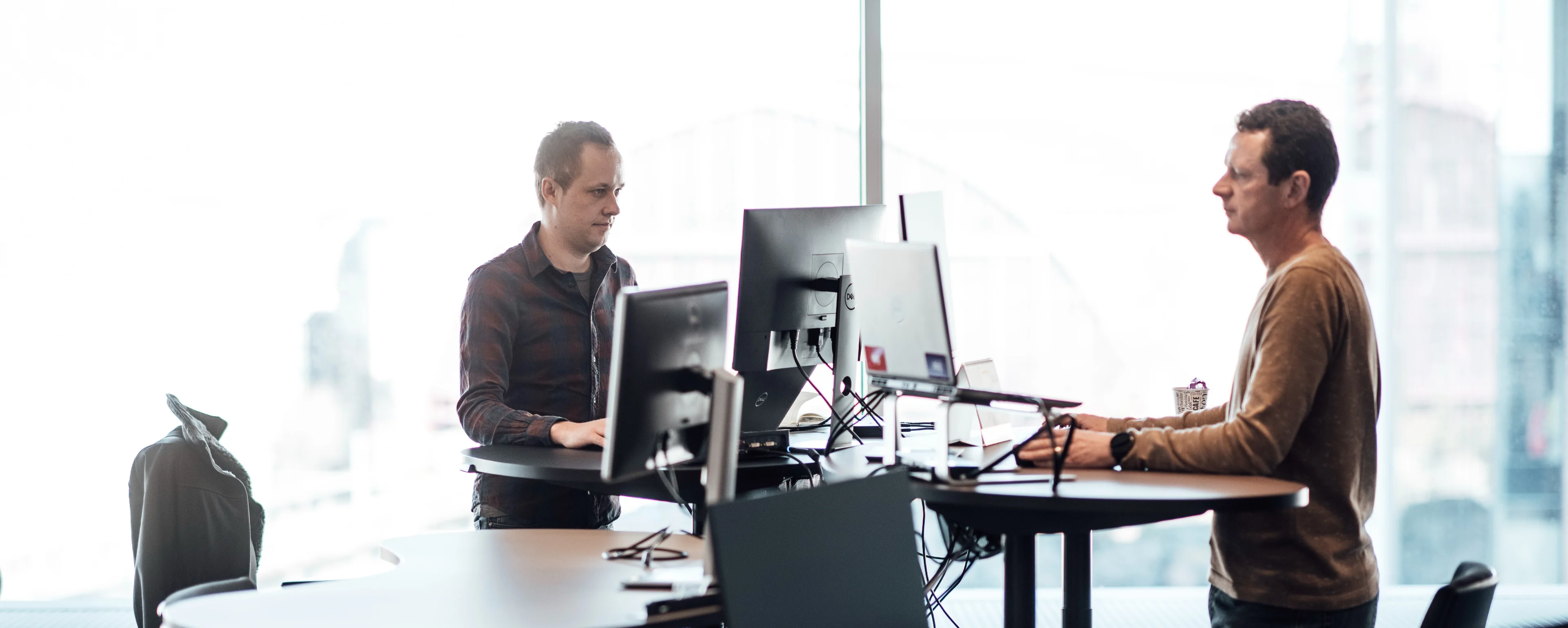 two people working on computers at their desk