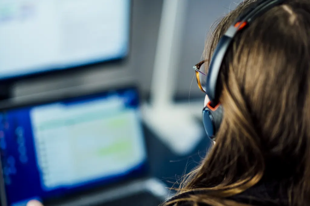 Woman working on a computer with headphones on