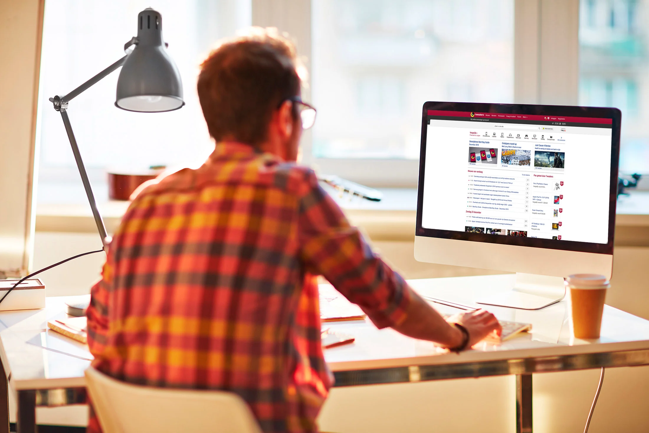 Man looks at Tweakers' website on his desktop