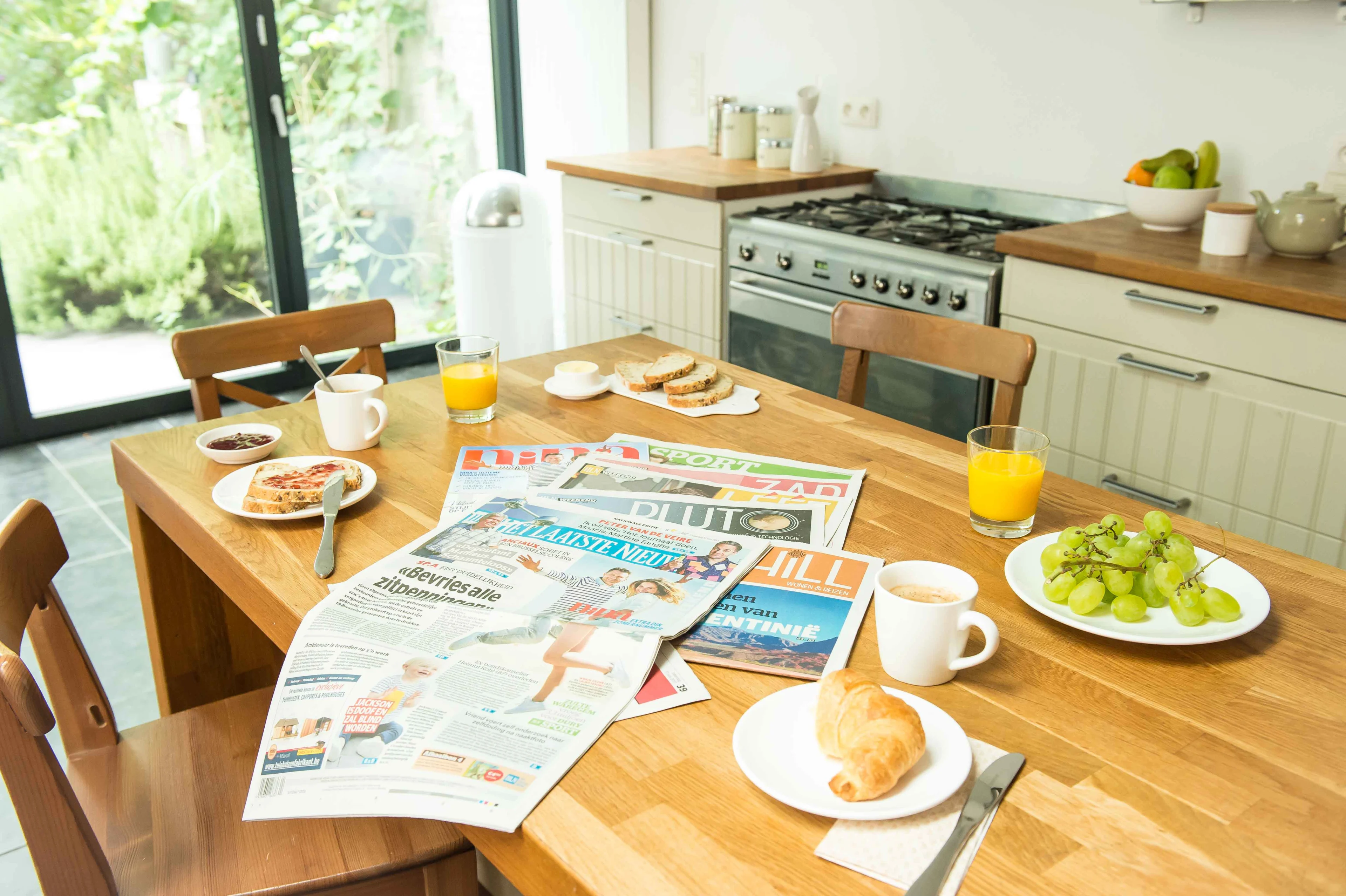 De krant Het Laatste Nieuws op de ontbijttafel met zijn bijlages