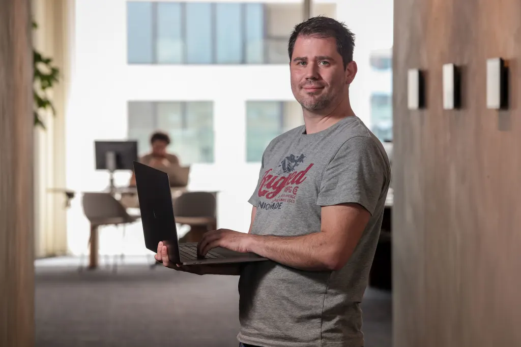 man in a hallway with laptop