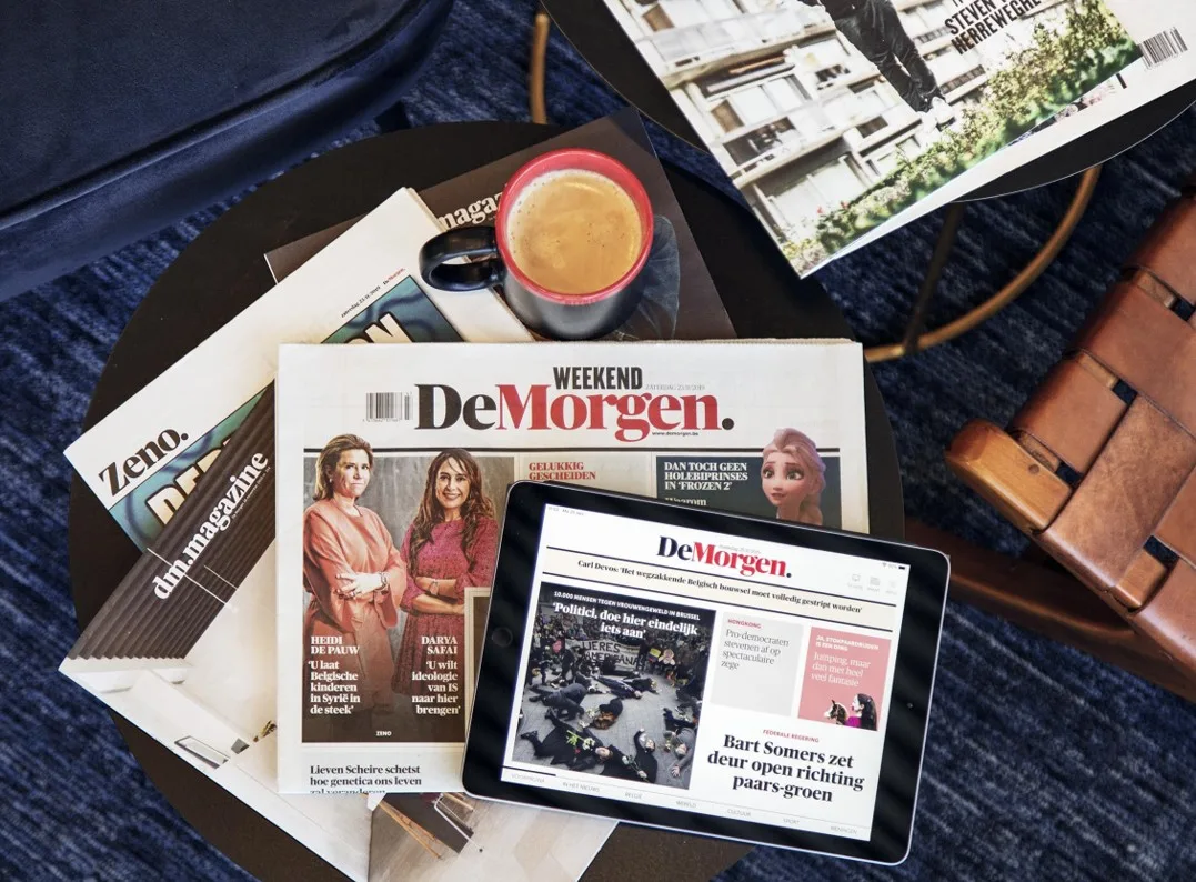 Top view of De Morgen newspaper and derivative brands on the table