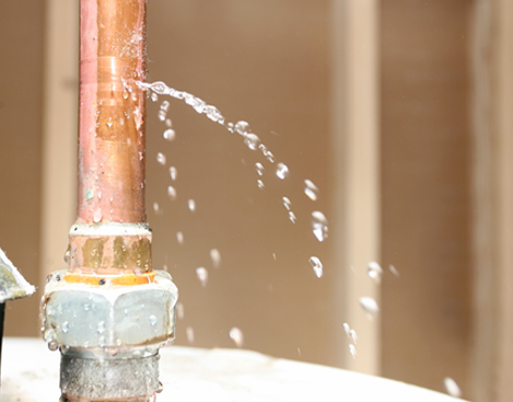 Water leaking out of a pipe on top of a water heater