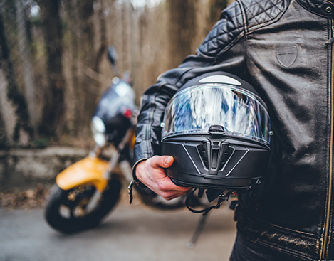 Motorcyclist holding helmet equipment