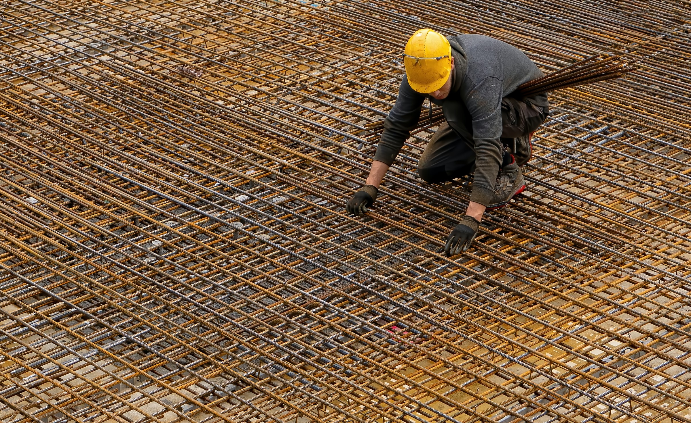 A construction worker handling rebar, the lowest quality and profit margin of steel products. This is what mini mills first produced.