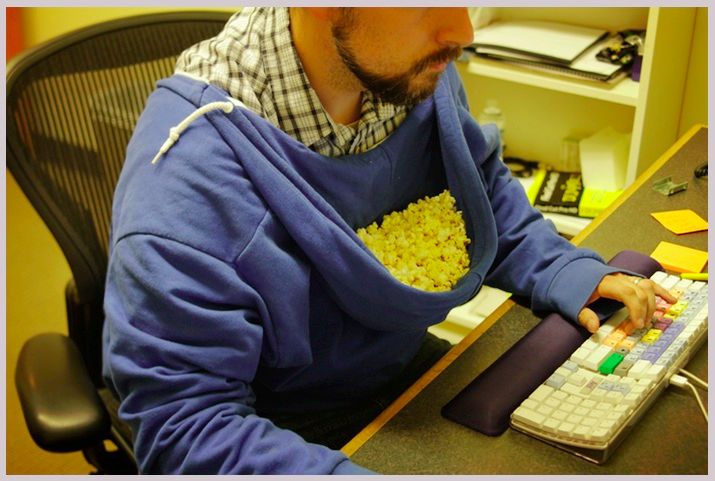 man eating popcorn from hoodie