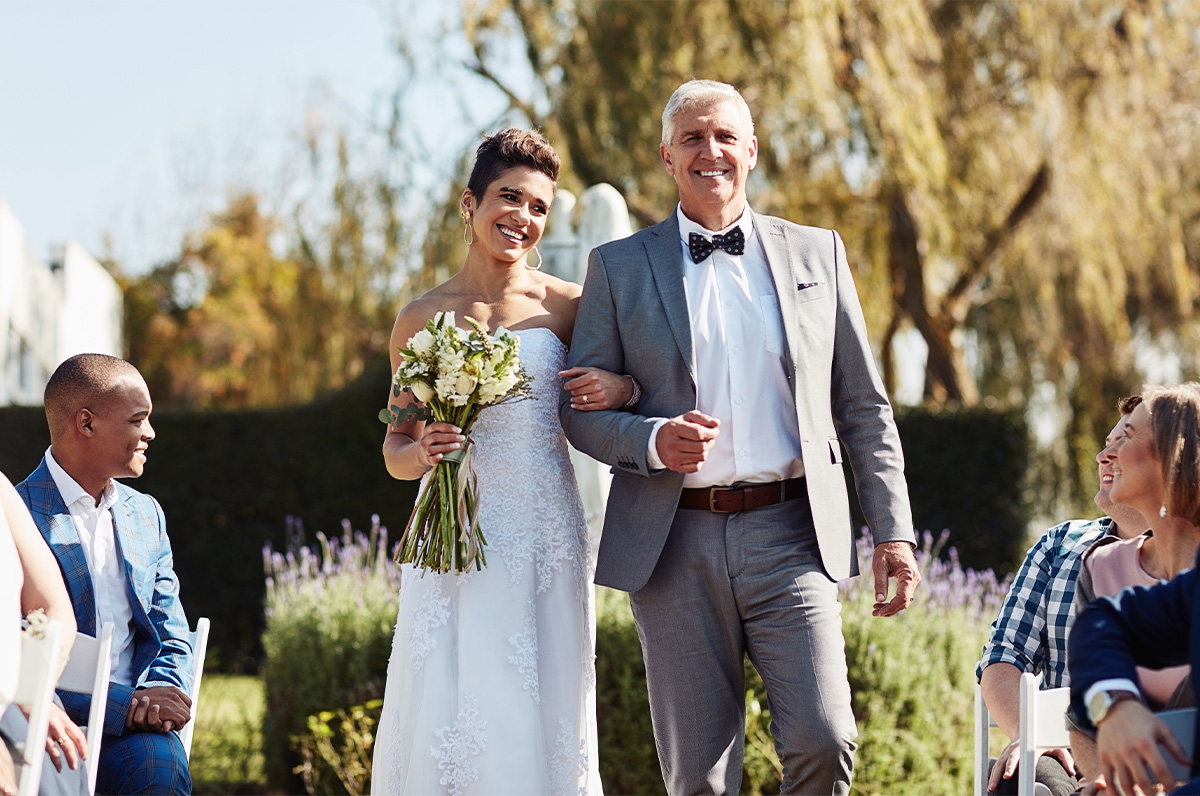 Father and daughter walking down the aisle smiling