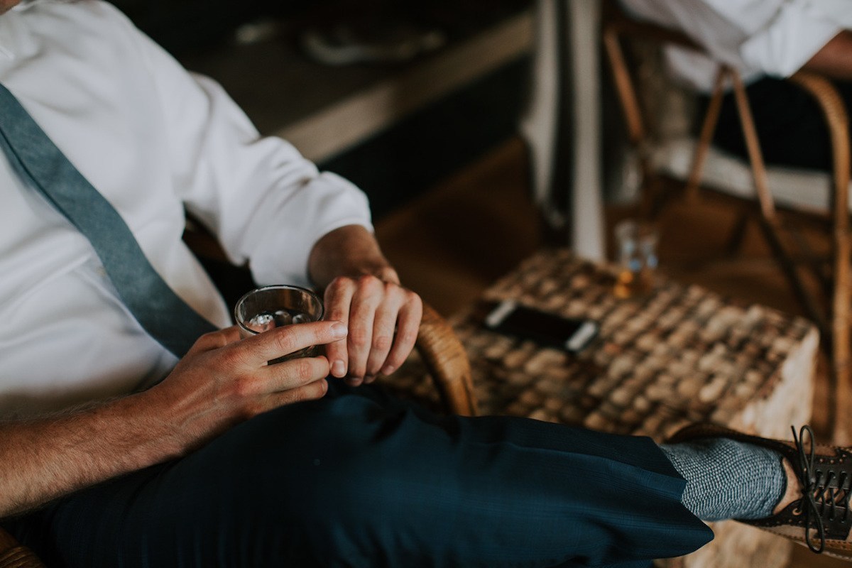 Groom Portrait relaxing, holding a glass with drink and ice cubes