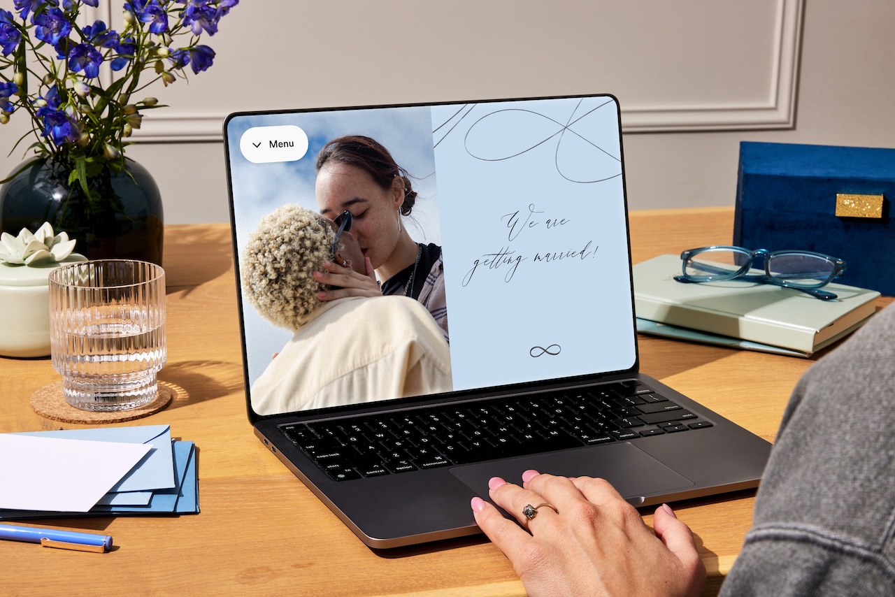 Laptop open to screen of couple's wedding website