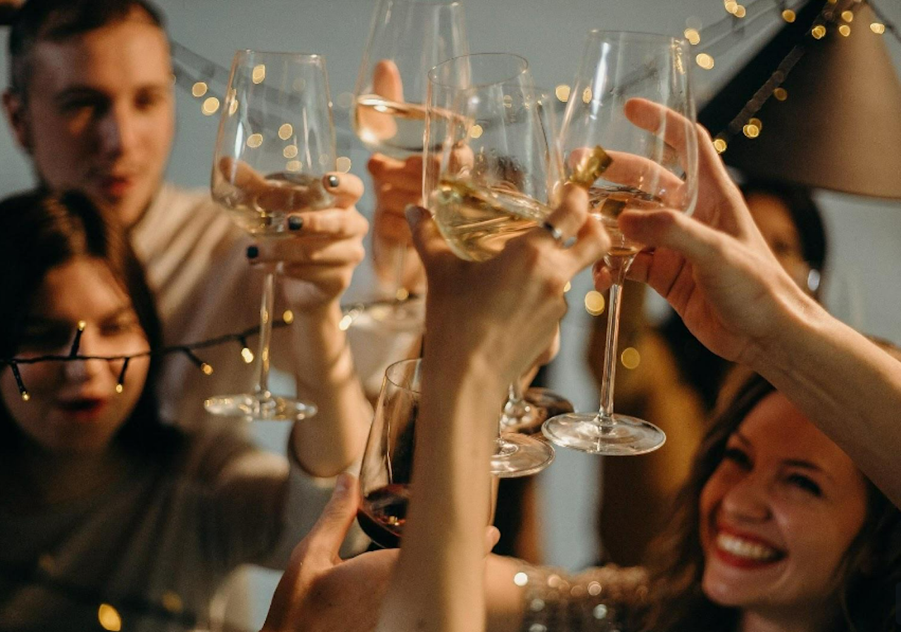 People smiling and clinking wine glasses at a party