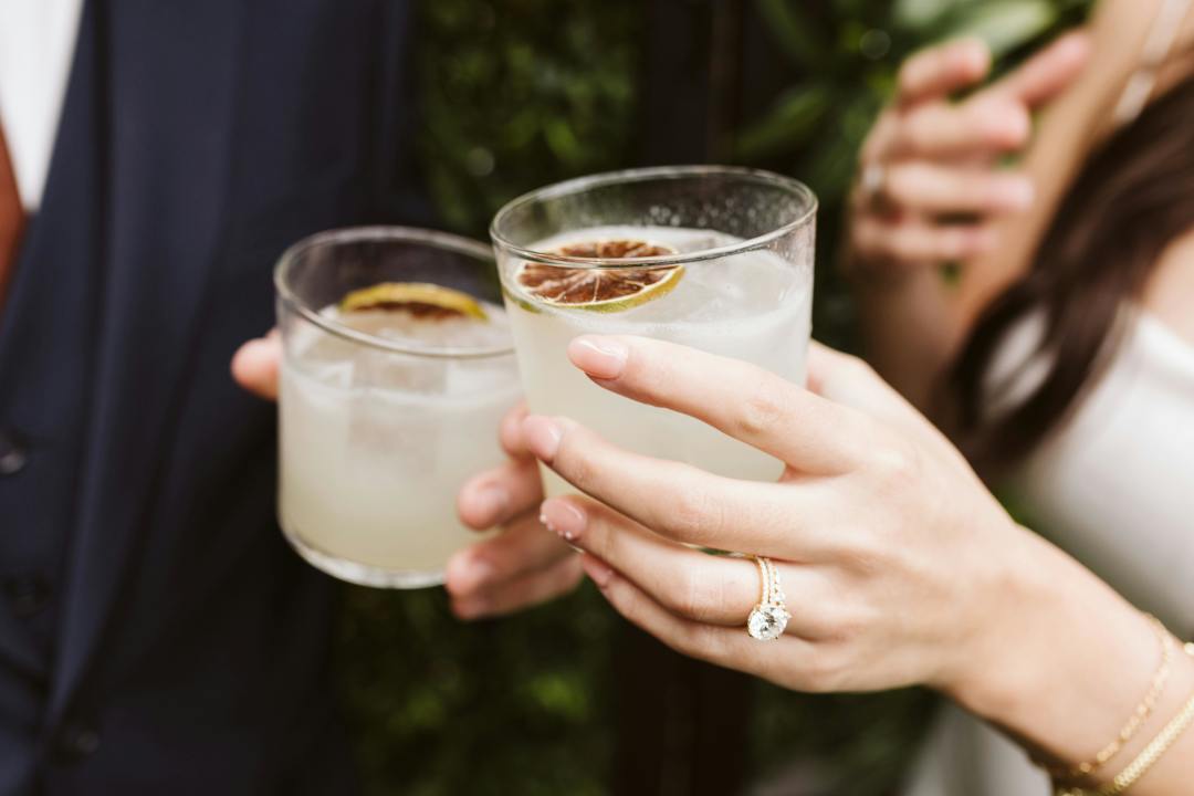 Bride and groom with signature cocktails in hand