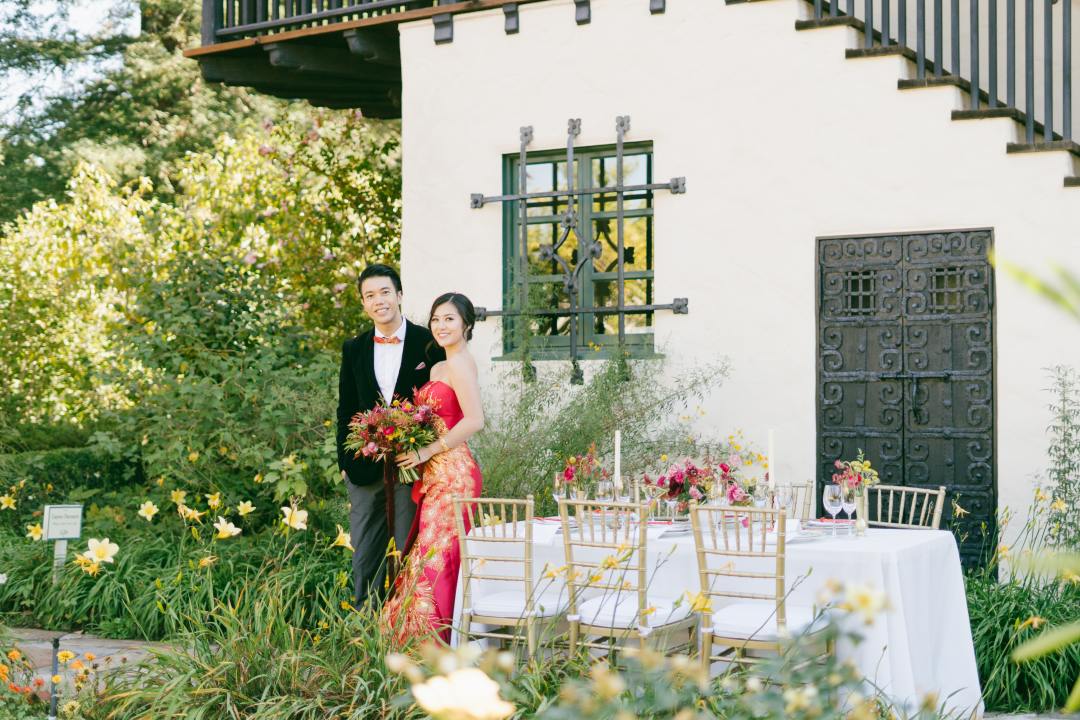 East Asian couple at an outdoor wedding reception table