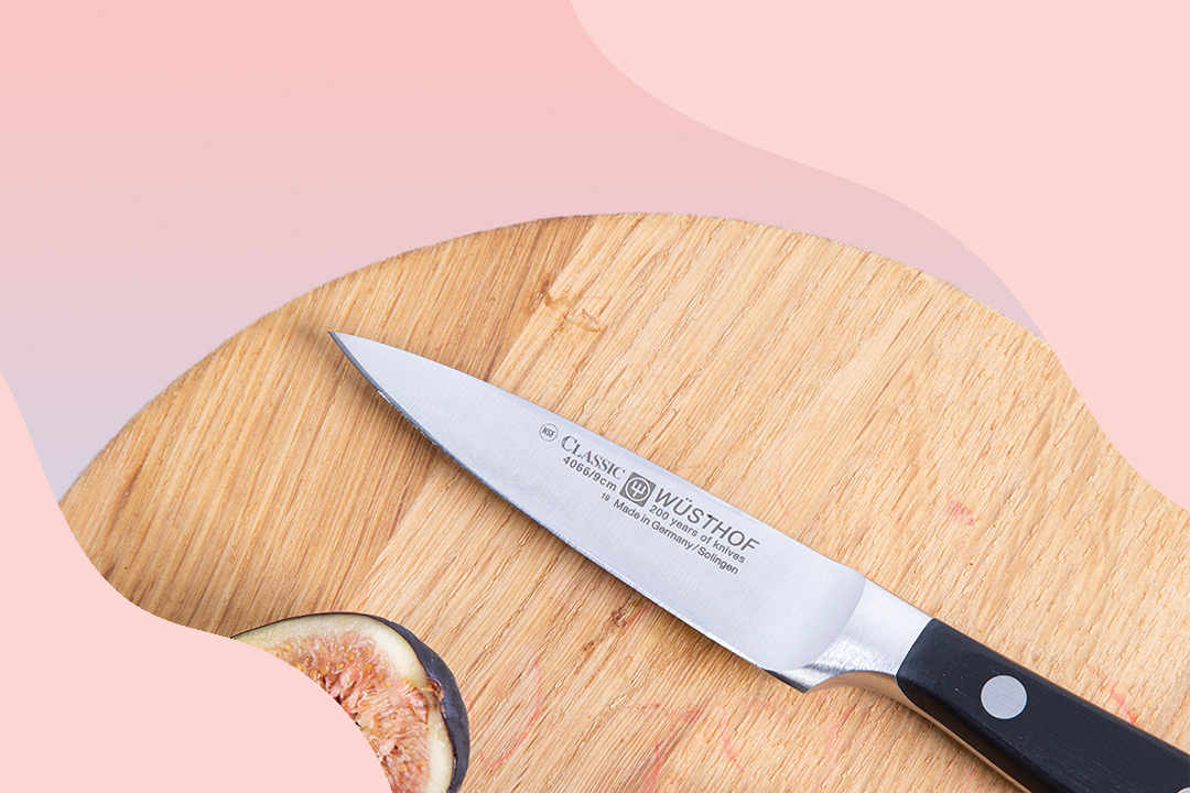 kitchen knife surrounded by freshly chopped radishes on wooden cutting board