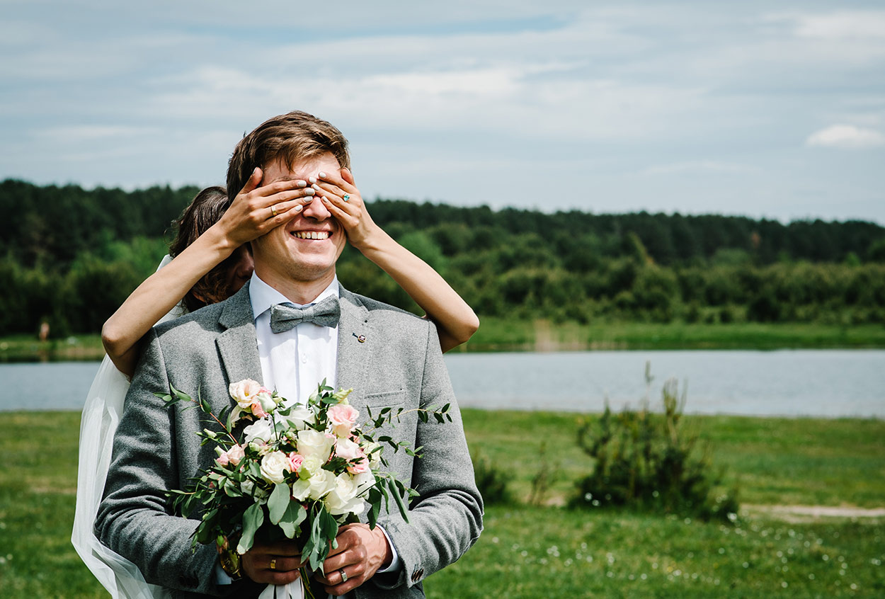 bride covering the groom's eyes during their wedding photoshoot