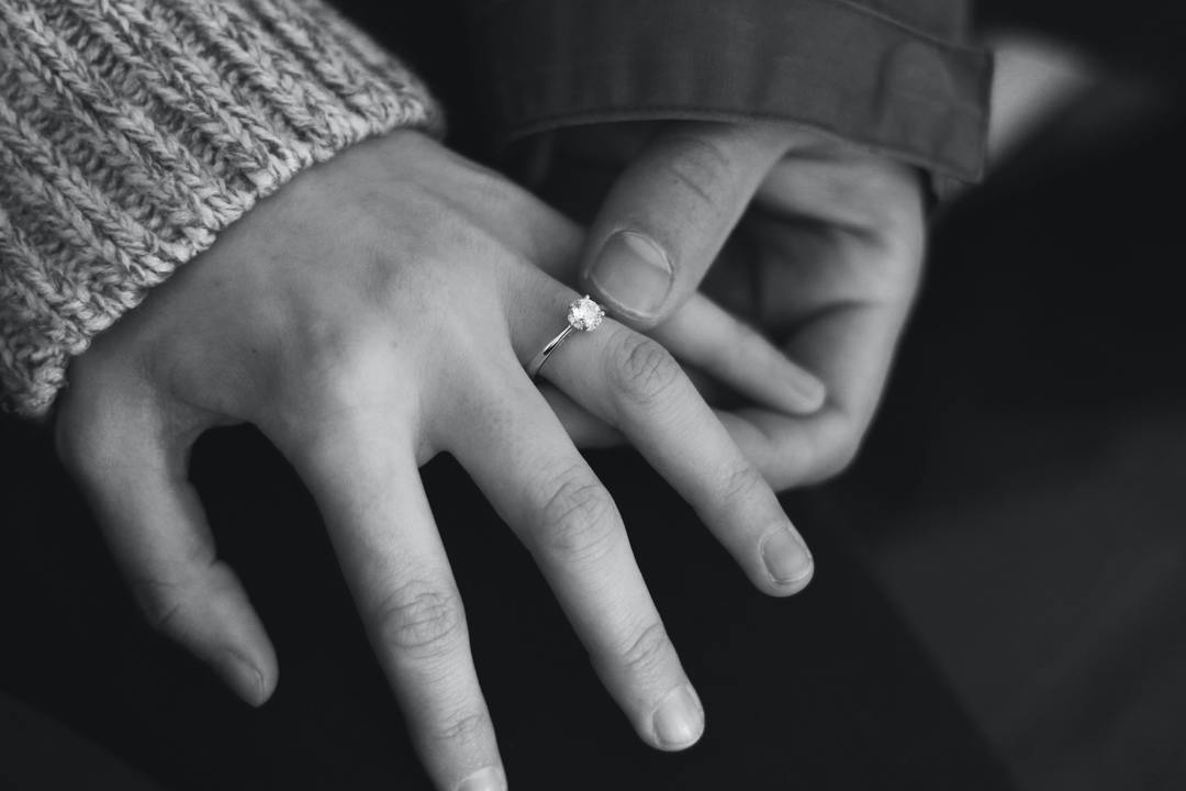 black and white photo of wedding ring on hand