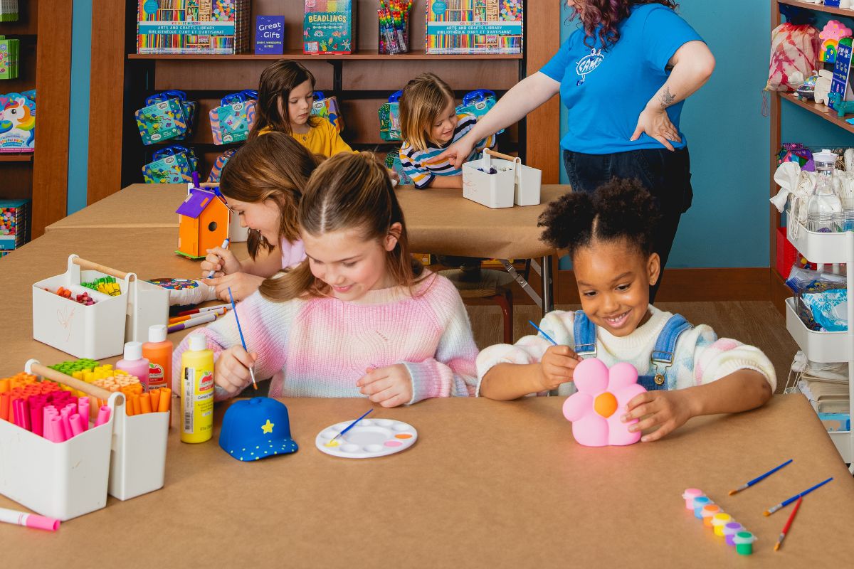 Children smiling while painting different crafts in the CAMP Maker Studio