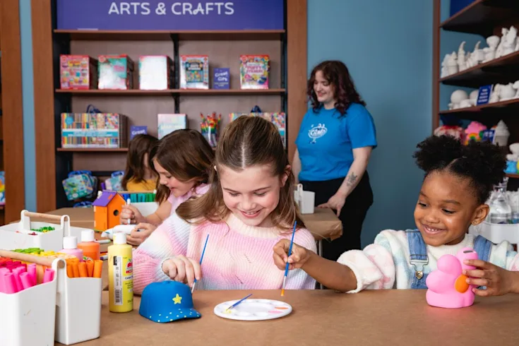 Two children painting crafts at a CAMP store. CAMP offers a variety of crafting options in each of the locations across the country.