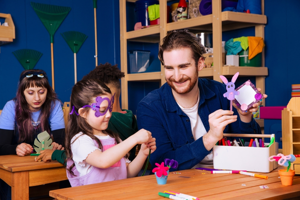 Dad and daughter making crafts in Bluey's Backyard shed at CAMP