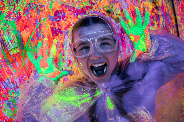 Child playing at the Blacklight Splatter Room at CAMP