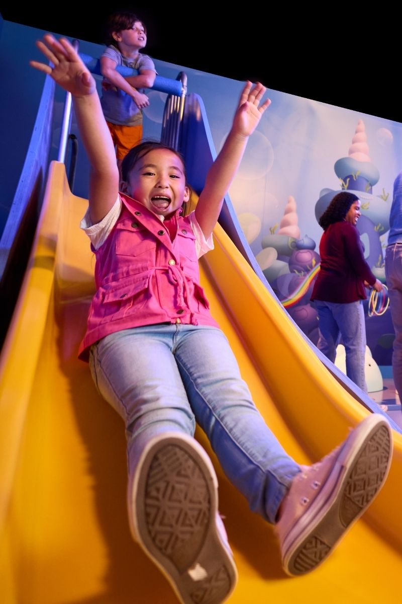 Child going down slide at Gabby's Dollhouse x CAMP experience