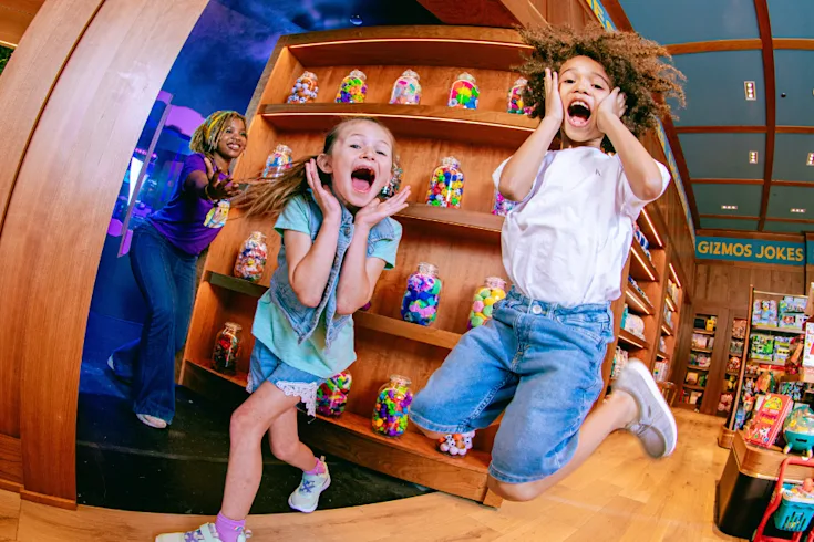 Two Kids Leaping for joy about to enter behind the Magic Door at CAMP. Experience rotating immersive experiecnes behind the Magic Door at CAMP.