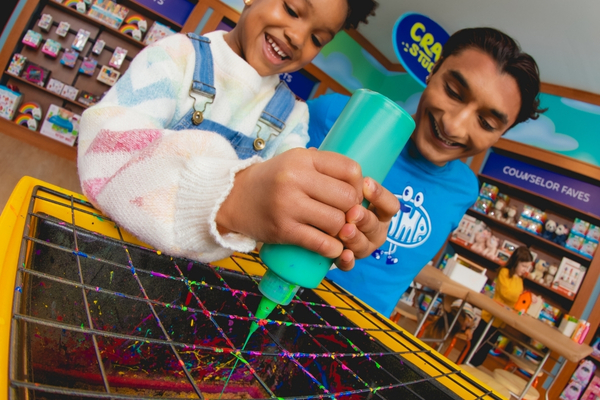 Child making spin art with a counselor at the CAMP Maker Studio