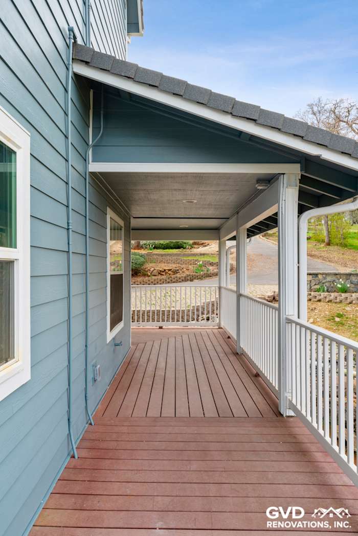 Newly installed James Hardie siding in blue with a covered porch and wood decking in Shingle Springs, CA